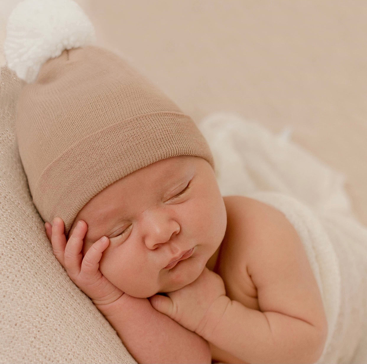 Tan newborn hospital hat with white pom