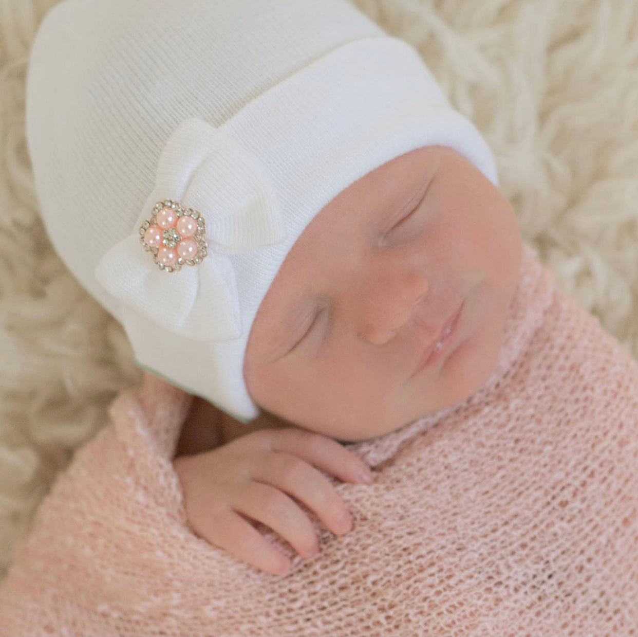White newborn hospital hat with tiny bow detail